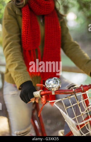 Close up of vintage bike bell, basket and handlebars with girl in urban fashion riding bicycle outdoors.