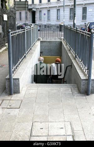 a couple walking down a stairway in the city of milan Stock Photo