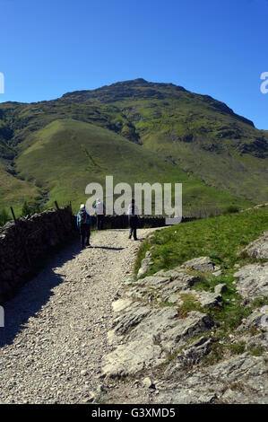 Three Walkers Heading Towards Oxendale with the Wainwright Mountain Pike of Blisco ahead of them in Langdale, Cumbria UK Stock Photo