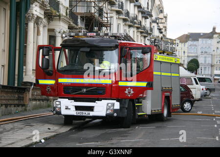 AN EAST SUSSEX FIRE & RESCUE VOLVO PUMP ATTENDING AN EMERGENCY INCIDENT WITH HOSES ON THE GROUND AROUND THE VEHICLE Stock Photo