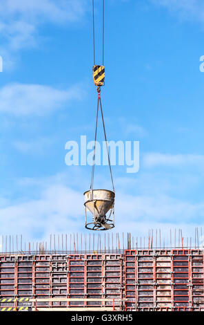 Tower crane lifting cement mixing container Stock Photo