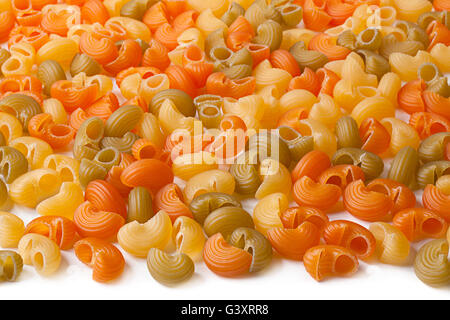 Multicolor dry swirl pasta closeup background Stock Photo