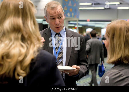 Businessman talking casually with businesswomen at a conference - Washington, DC USA Stock Photo