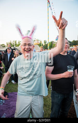 Middle aged bald man in silly headgear 'dad dancing' to Public Enemy at music festival, Oxford UK Stock Photo