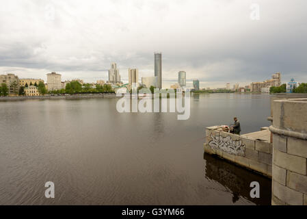 City Pond Lake in Yekaterinburg Russia with person fishing on an overcast day Stock Photo