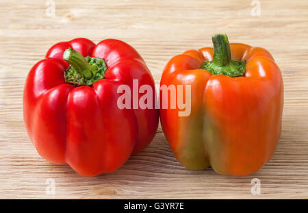 Two red sweet bell peppers on a wooden background Stock Photo