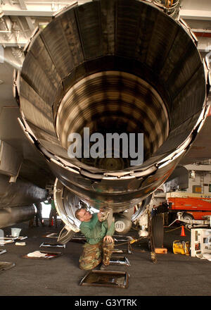 Aviation Machinist's Mate performs routine maintenance on an F-14B engine. Stock Photo