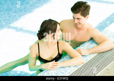 Portrait of a smiling young couple in a swimming pool. Stock Photo