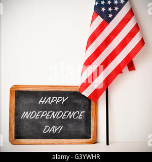 a wooden-framed chalkboard with the text happy independence day written in it and a flag of the United States, on a white backgr Stock Photo