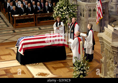 The officiating clergy for the funeral service pray over a casket. Stock Photo