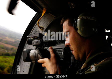 U.S. Air Force Airman takes video aboard a U.S. Army UH-60A Black Hawk. Stock Photo
