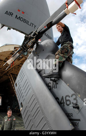Airman assists in loading a HH-60G Pave Hawk onto a C-5 Galaxy. Stock Photo
