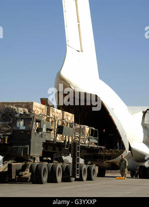 A 60K Tunner loader pulls away after receiving cargo from a Russian AN-124 aircraft. Stock Photo