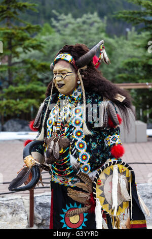 BANFF, CANADA- JUL 3, 2014: A native Blackfoot indian chief wearing a split-horn bonnet dances at a performance in Banff. Stock Photo