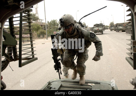 U.S. Army Specialist entering a Stryker assault vehicle in Baghdad, Iraq. Stock Photo