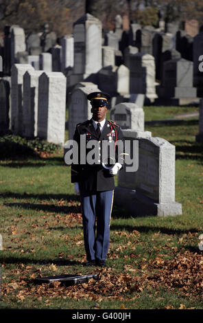 An Army soldier stands in the Cypress Hills National Cemetery waiting to play taps. Stock Photo