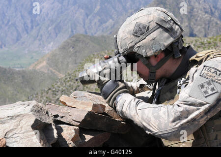 U.S. Army soldier monitors an Afghan National Army visit to Nishigam village in Afghanistan. Stock Photo