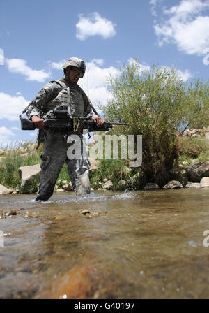 U.S. Army soldier crosses a stream while on patrol in the Zabul province of Afghanistan. Stock Photo