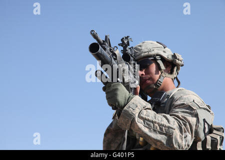 U.S. Army soldier scans the area with an M203 grenade launcher. Stock Photo
