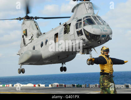 A CH-46E Sea Knight helicopter takes off from the flight deck of USS Essex. Stock Photo