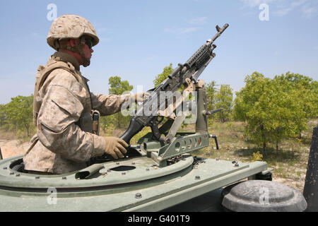 A Marine prepares to fire his M240 machine gun while riding in a vehicle turret. Stock Photo
