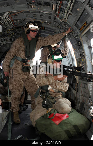 A scout sniper fires his MK-11 sniper rifle from a CH-46 Sea Knight. Stock Photo