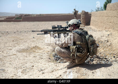 U.S. Marine uses the mounted scope on his M110 sniper system to provide overwatch. Stock Photo