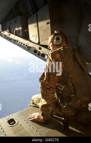 U.S. Air Force Commander sits harnessed on the back ramp of an Afghan Air Force C-27 Spartan. Stock Photo