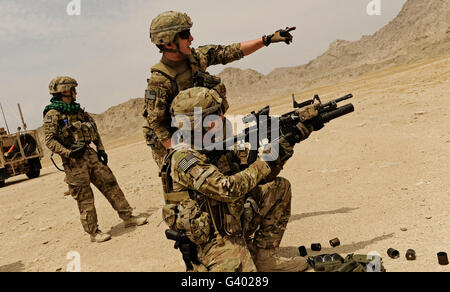 Soldier directing a fellow soldier where to aim the M-203 grenade launcher. Stock Photo
