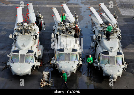 Sailors perform maintenance on MH-60S Sea Hawk helicopters.