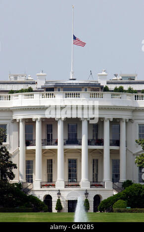 The American flag flies at half-staff atop the White House. Stock Photo