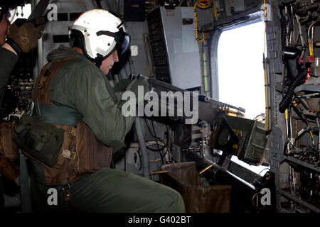 Crew chief fires an M2 .50-caliber heavy machine gun from a CH-53E Super Stallion.