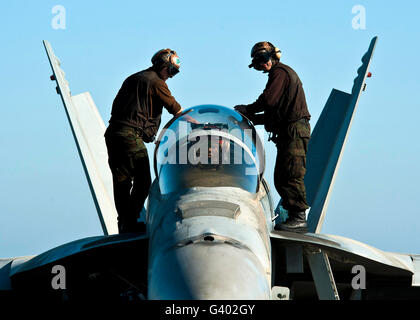 U.S. Navy sailors wipe down the canopy of an F/A-18F Super Hornet. Stock Photo