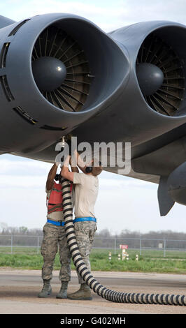 Airmen disconnect an aircraft hose from a B-52H Stratofortress engine. Stock Photo