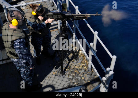 Sailor fires an M-240B machine gun aboard USS Wasp. Stock Photo