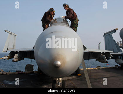 Airmen clean the canopy of an F/A-18F Super Hornet. Stock Photo