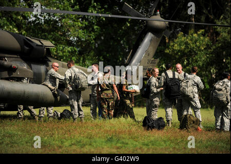 Soldiers unload medical supplies, food and water from a UH-60 Blackhawk. Stock Photo