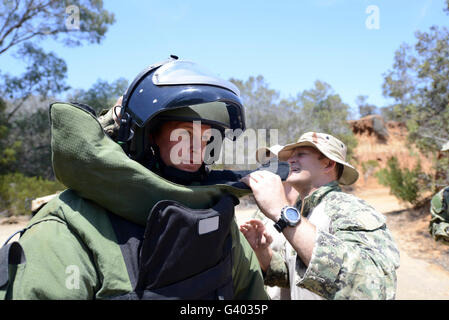 Soldier provides assistance in putting on a bomb suit. Stock Photo