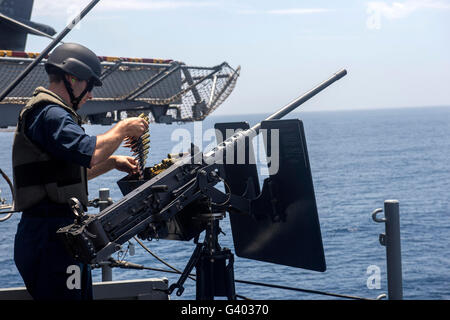 Technician loads a .50-caliber machine gun with ammunition. Stock Photo