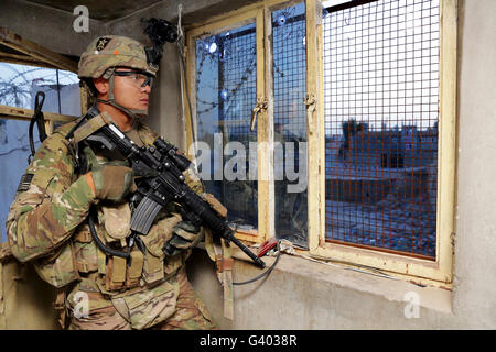 U.S. Army Specialist monitors his surroundings from a guard post. Stock Photo