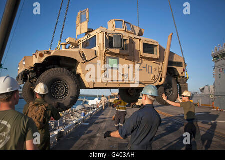 U.S. Marines guide a Humvee onto USS Bonhomme Richard. Stock Photo