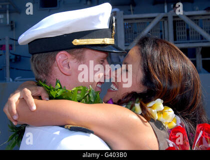 U.S. Navy sailor greets his wife during a traditional first kiss ceremony. Stock Photo