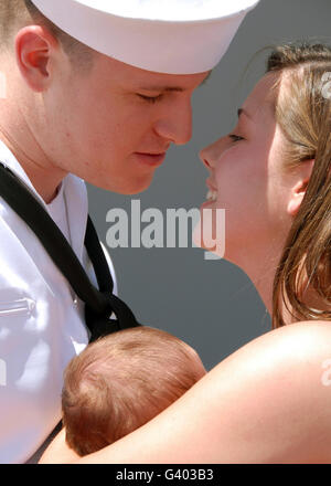 A father is reunited with his wife and baby after returning to Naval Station Pearl Harbor. Stock Photo