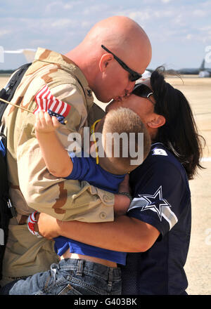 Aviation Structural Mechanic receives a hug and kiss from his wife and son. Stock Photo