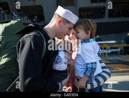 U.S. Navy sailor greets his family on the pier at homecoming. Stock Photo