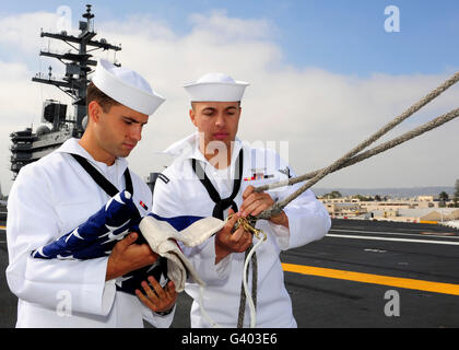 Sailors prepare to raise the American flag on the flight deck of USS Ronald Reagan. Stock Photo