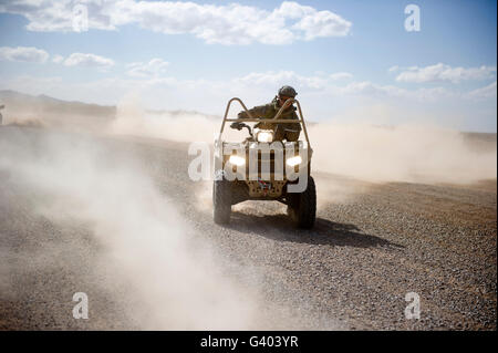 A U.S. Soldier performs off-road maneuvers with a LTATV. Stock Photo