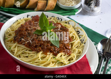 Traditional Italian dish of Spaghetti Bolognese/Bolognaise served with Garlic Bread/Baguette and freshly grated Parmesan cheese. Stock Photo