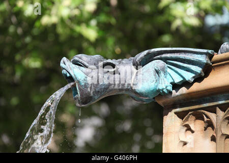 Gargoyle spouting water on the Queen Victoria Jubilee Fountain in Manchester Stock Photo