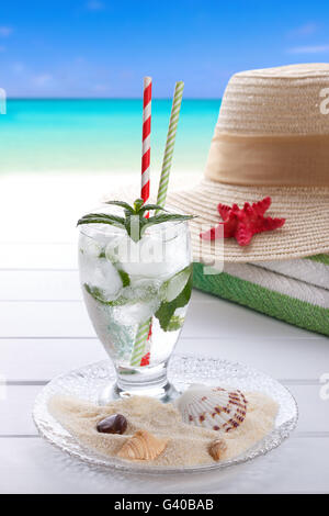 Fizzy summer soda drink with mint on white wooden background, beach accessories Stock Photo